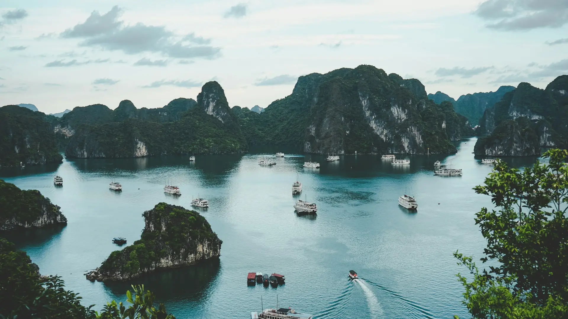 Boats cruising through Ha Long Bay near limestone hills in Vietnam